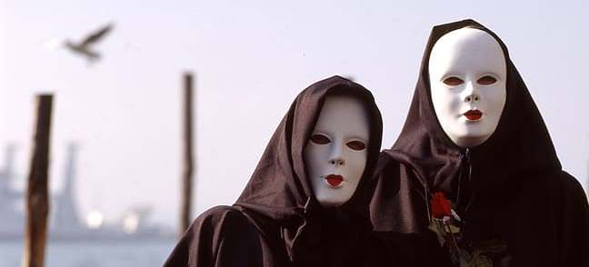 two-person-wearing-black-capes-and-white-masks